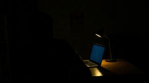 Personne en conversation avec une IA sur ordinateur portable le soir